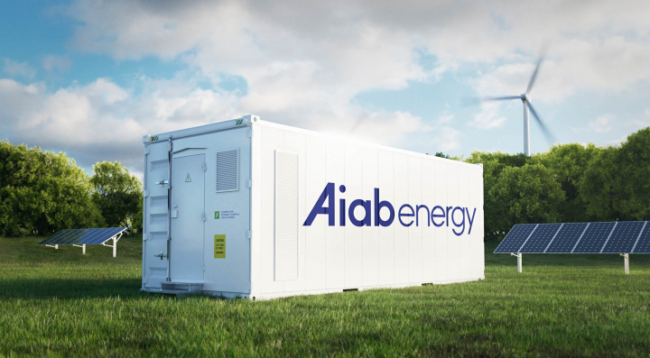 Aiab Energys BESS-container för energilagring med solpaneler och vindkraft i bakgrunden.